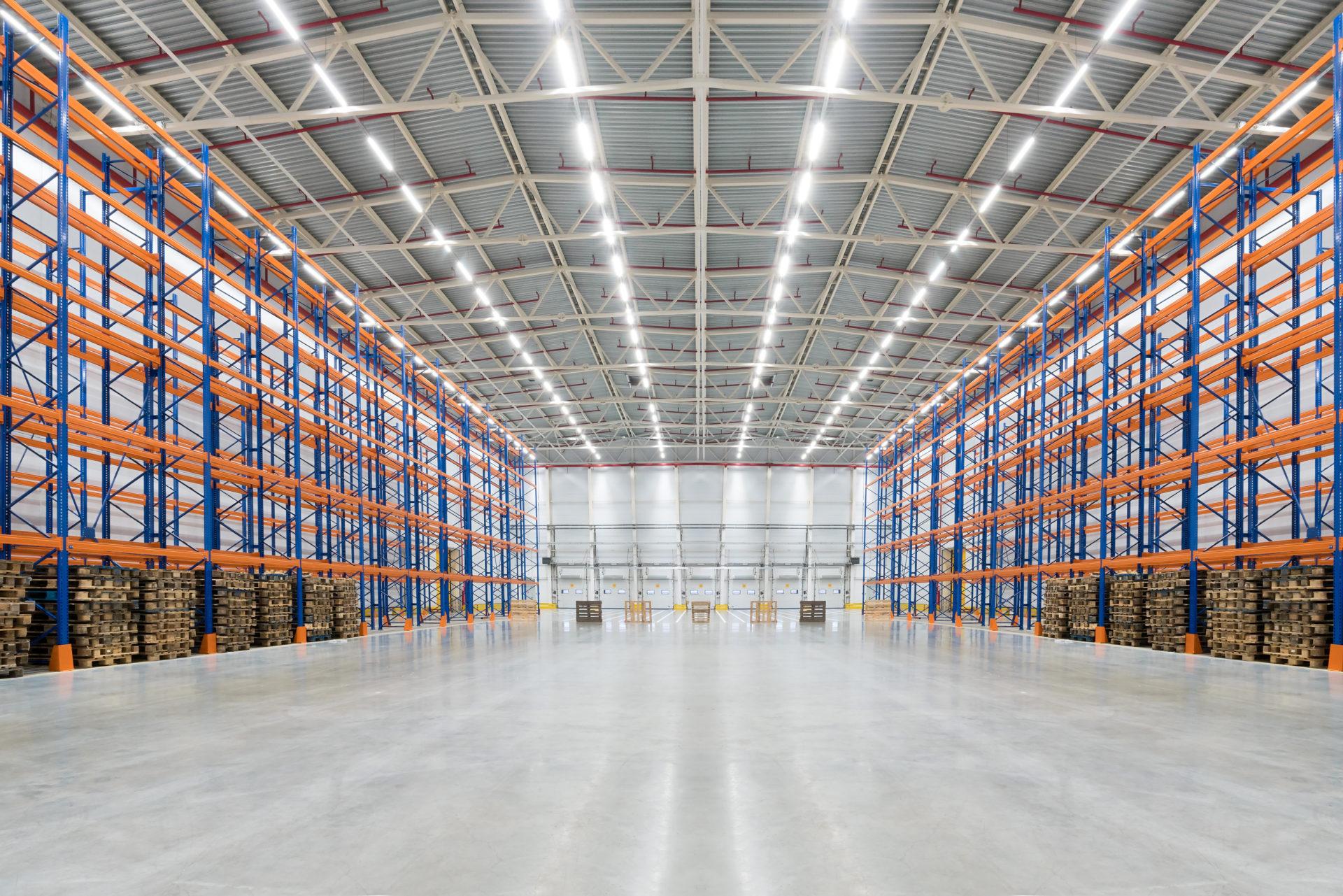 Empty huge distribution warehouse with high shelves and pallet